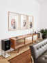 Symmetrie ist hier alles – deshalb hängen auch exakt drei Kunstwerke (von Max Piva) über dem dreigliedrigen Sideboard im Wohnzimmer. | Foto: © Mark Glassner