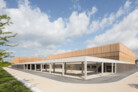 Um den Baukörper zu gliedern, entschieden sich die Architekten für eine versetzte Anordnung der beiden Hallen. Diese erheben sich oberhalb eines Sockelbandes aus Beton und lassen aufgrund ihrer versetzten Anordnung zwei geschützte Freibereiche entstehen: den Eingangshof und den Vereinshof mit integrierter Sportgaststätte. | © Marcus Ebener