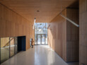 The entrances to the larger building are found in three inviting, wood-clad passages that punch through the building. Image: © Ossip van Duivenbode