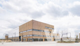 Das mit Holz verkleidete Sockelgeschoss des Kopfbaus öffnet sich durch eine großzügige und einladende Glasfassade zur Hauptachse Rue du Sausset. Dort sind Büros, Co-Working-Spaces und ein Restaurant untergebracht. | © Auer Weber / Foto: Nicolas Grosmond